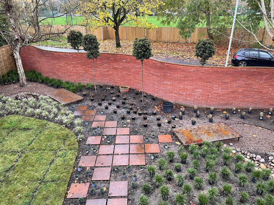 View across the completed Marlow garden showing newly planted borders, Corten steel edging, and a patterned pathway — an example of modern eco garden design in Marlow.